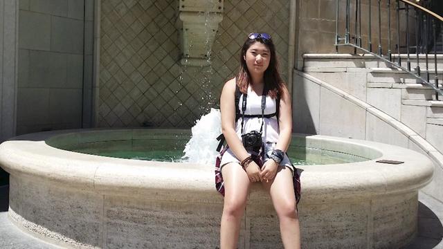 Victoria Lee sitting on the edge of a fountain 