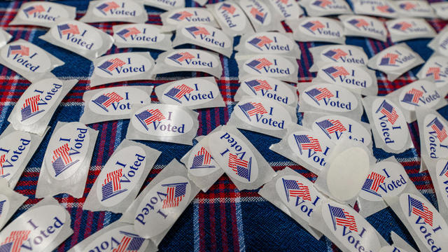 'I Voted" stickers cover a table at a polling place 